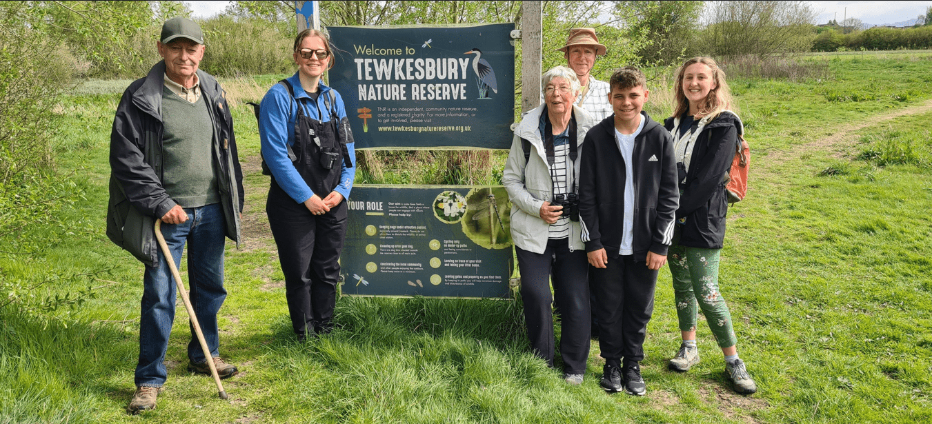 The Tewkesbury Nature Reserve team standing in a field and smiling at the camera